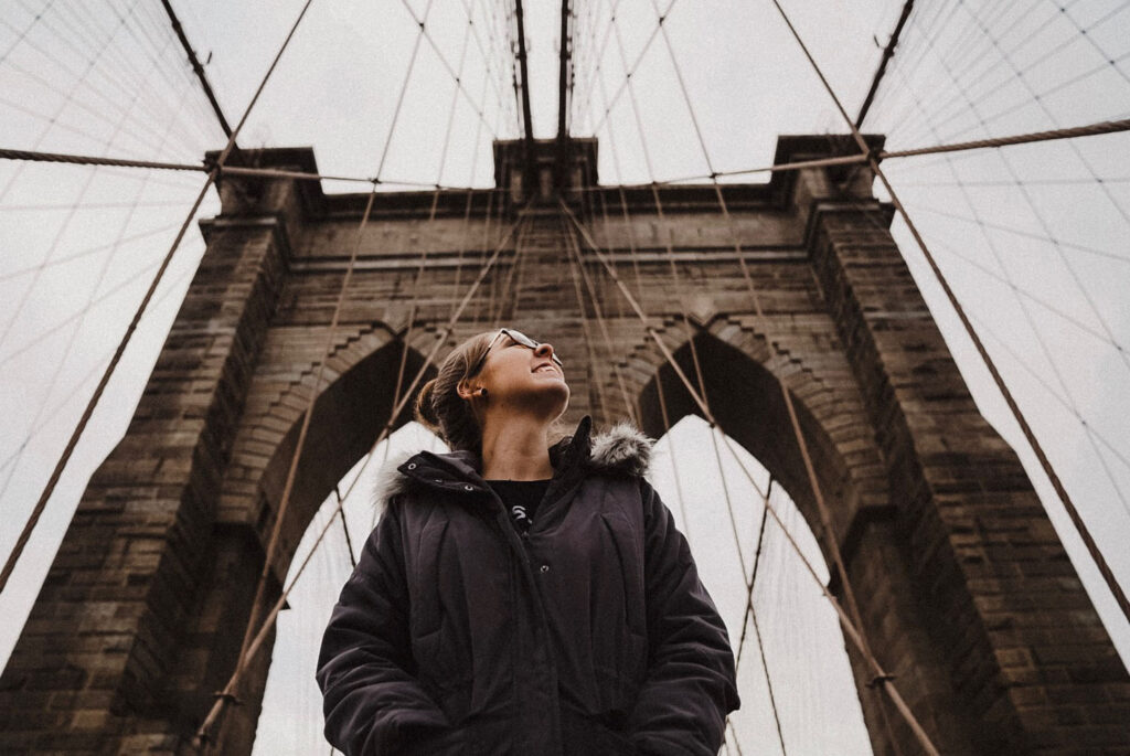 Woman looks up on Brooklyn Bridge